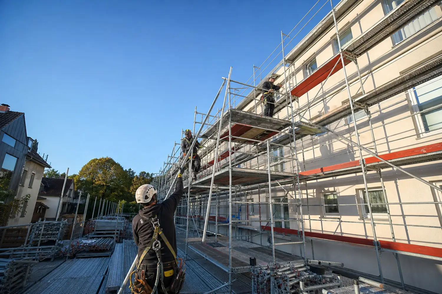 Polnische Gerüstbauer montieren ein Fassadengerüst an einem Wohnhaus
